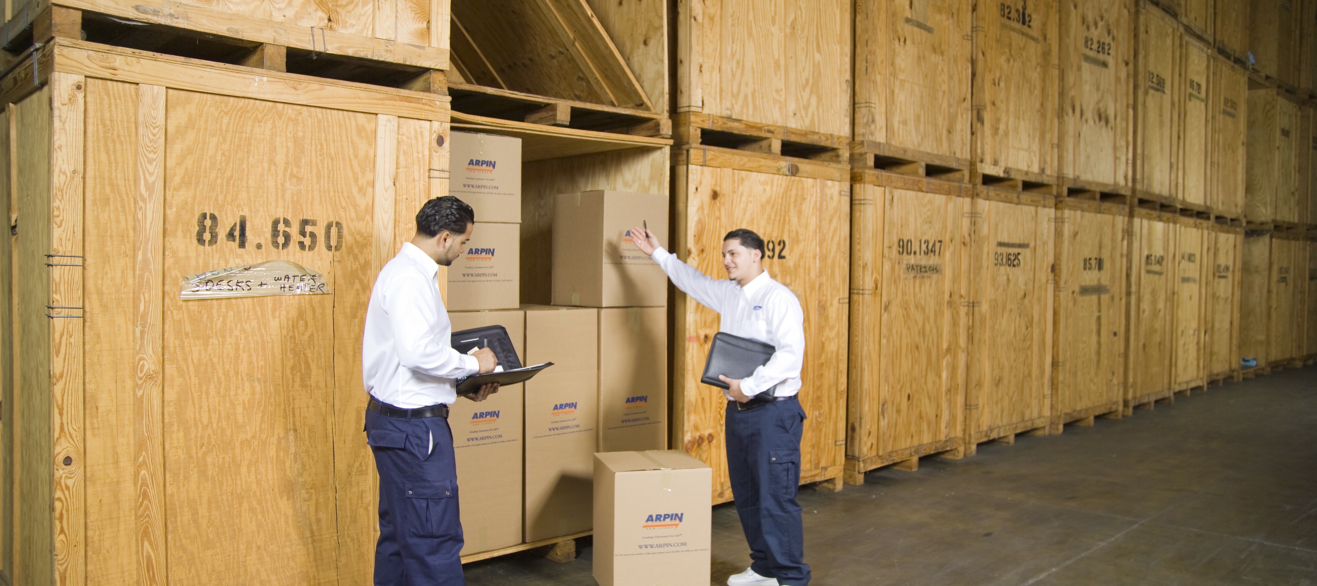 Two men taking inventory outside a storage unit